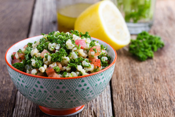 Tabbouleh salad with bulgur, fresh parsley, tomatoes and  salad  dressing