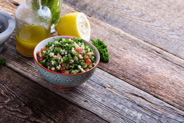 Tabbouleh salad with bulgur, fresh parsley, tomatoes and  salad  dressing