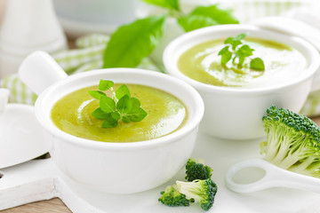 Broccoli soup in bowls on wooden kitchen table closeup. Healthy vegetarian dish. Diet food