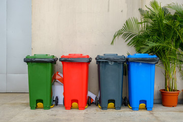 Recycle garbage bins or Sorted recycling bins in multiple color beside the building