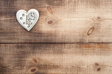 Wood heart placed nicely on a vintage wooden background.