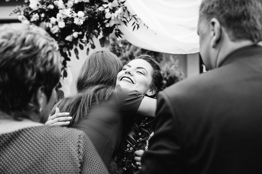 the guests embrace the bride after a wedding ceremony on a black and white photography