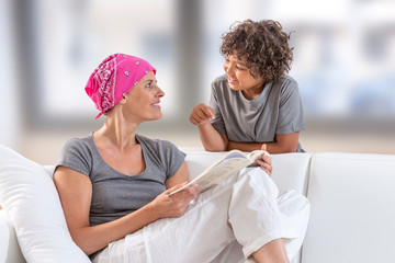 Ill woman with headscarf reading book to her son