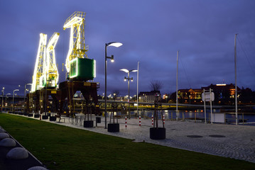 Colorfully illuminated antique cranes on the quay of Szczecin Łasztownia. 