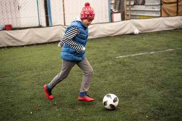 Cool african american football player boy playing football with his brother downstairs. Active mixed kids. School boys free time. Children and sport. Brothers game. Shooting in December 2018 Istanbul