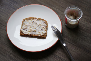 slice of bread and dripping or crackling fat or lard with greaves called Schmalzbrot in Germany, with selective focus and shallow depth of field