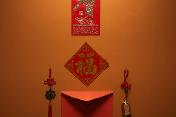 red envelope, hieroglyphs and traditional decorations on brown background, chinese new year concept