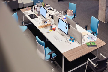 Desk in modern office with blank monitors
