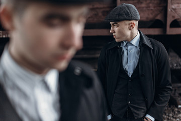 brutal gangsters posing on background of railway carriage. england in 1920s theme. fashionable confident man. atmospheric moments. space for text