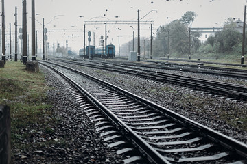 Fototapeta na wymiar railway tracks. transportation roads and platform with carriage. foggy rainy atmosphere on railroad.