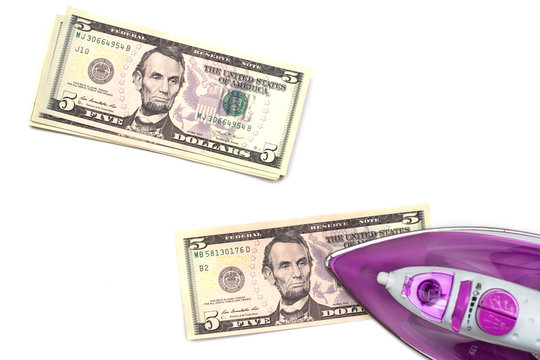 Ironing A Five Dollar Bank Note On White Background