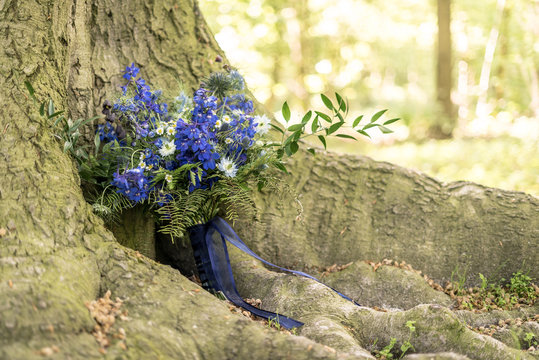 bouquet of flowers in the forest placed against a tree
