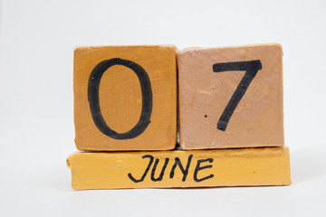 june 7th. Day 7 of month, handmade wood calendar isolated on white background. summer month, day of the year concept
