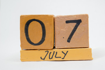 july 7th. Day 7 of month, handmade wood calendar isolated on white background. summer month, day of the year concept