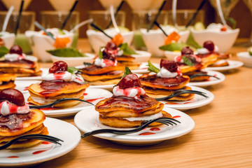 Pancakes with jam and glasses with a cocktail on the table.