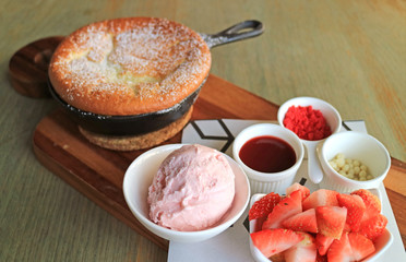 Closed Up a Scoop of Ice Creme with Chopped Fresh Strawberries for Topping on the Fluffy Souffle Pancake Served on Wooden Tray 