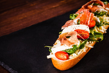 Long sandwich on black stone plate