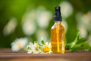 Essence of flowers on table in beautiful glass bottle