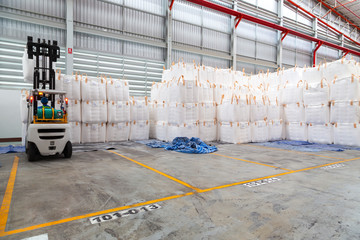 Forklift is handling jumbo bags in large warehouse for distribution to customer, import export...
