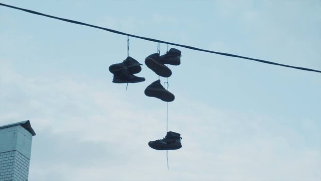 Six pairs of sneakers hanging on electric wires at a height of nine meters