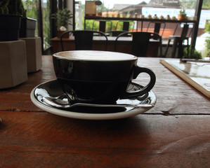 Hot art Latte Coffee in a cup on wooden table and Coffee shop