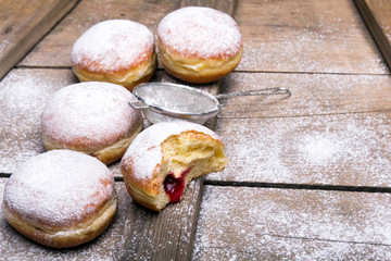Traditional Polish donuts on wooden background.  Tasty doughnuts with jam.