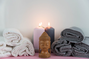 Obraz na płótnie Canvas Beautiful spa still life composition. Twisted towel, aromatic candles and Buddha statue. Concept of cosmetology, weight loss, cellulite, balance and meditation, relax, massage, beauty spa treatment.