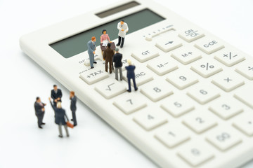 Miniature people Pay queue Annual income (TAX) for the year on calculator. using as background business concept and finance concept with copy space  for your text or  design.