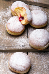 Traditional Polish donuts on wooden background.  Tasty doughnuts with jam.