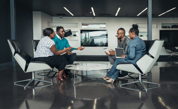 Team of african bussines people sitting in a modern office and talking during an work meeting