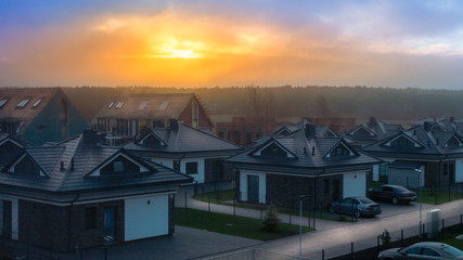 Red sunrise over small houses