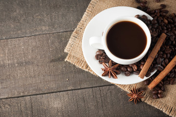 Coffee cup and beans on a rustic background. Coffee Espresso and a piece of cake with a curl. Cup of Coffee and coffee beans on table.
