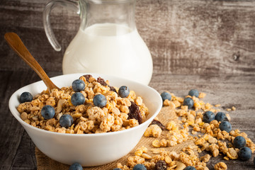 Healthy breakfast concept with oat flakes and fresh berries on rustic background. Food made of granola and muesli. Healthy banana smoothie with blackberries, honey and milk.