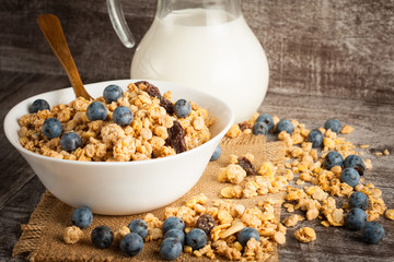 Healthy breakfast concept with oat flakes and fresh berries on rustic background. Food made of granola and muesli. Healthy banana smoothie with blackberries, honey and milk.