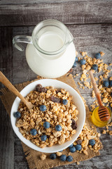 Healthy breakfast concept with oat flakes and fresh berries on rustic background. Food made of granola and muesli. Healthy banana smoothie with blackberries, honey and milk.