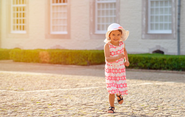 Little girl running on the street in city