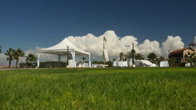 Morning view of buffet in nature made in white colours. Landscape is picturesque. Green grass, blue sky, warm weather