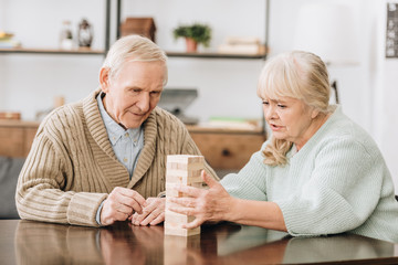 senior couple playing jenga game at home