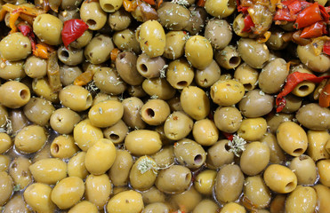 green pickled olives and some red peppers for sale in the Italia