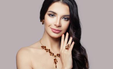 Woman jewelry. Smiling brunette woman with amber necklace, ring and earrings
