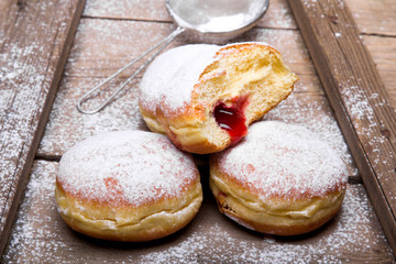Traditional Polish donuts on wooden background.  Tasty doughnuts with jam.