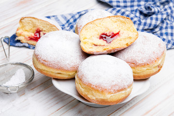 Obraz na płótnie Canvas Traditional Polish donuts on wooden background. Tasty doughnuts with jam.