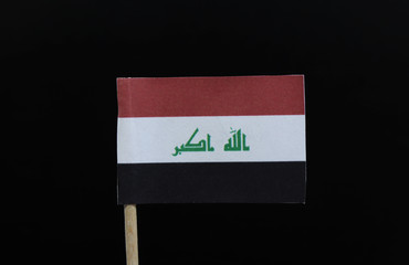 A unique flag of Iraq on toothpick on black background. A horizontal tricolour of red, white, and black, charged with the text  in green Kufic script, centered on the white stripe