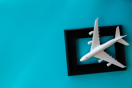 flat lay : white airplane model on blank picture frame isolate on blur background