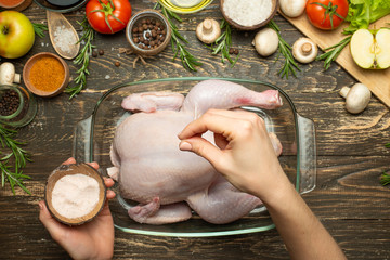 Cooking fresh chicken for a festive dinner, the hands of the chef salt and pepper the chicken concept recipe book, menu, restaurant business. Background, top view, Flat-lay