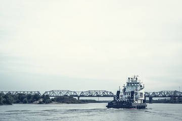 Iron barge and pusher tug boat on River. Large cargo barge transporting iron to main harbor for...