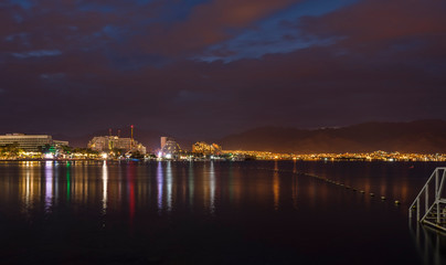 Night view on the gulf of Aqaba from the central beach of Eilat - famous tourist resort and recreational city in Israel
