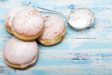 Traditional Polish donuts on wooden background.  Tasty doughnuts with jam.