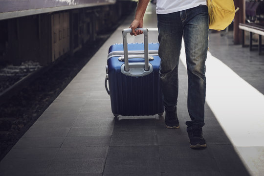 Young asian traveler with backpack in the railway, Man traveler tourist walking with luggage at train station. Active and travel lifestyle concept 