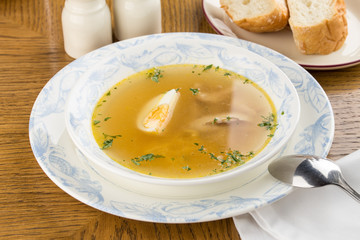 Dietary soup with chicken and egg on wooden table